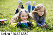 two blonde girl lie on grass in spring. Стоковое фото, фотограф Татьяна Яцевич / Фотобанк Лори