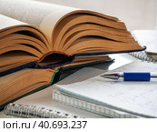 Two old thick books are on the table, one on top of the other. Nearby are notebooks with notes. Books and notebooks are open. The pen is on the notebooks. Background for education and libraries. Стоковое фото, фотограф Бузмакова Светлана / Фотобанк Лори