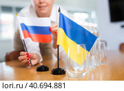 girl sets midget flags of Ukraine and Russia before international negotiations. Стоковое фото, фотограф Яков Филимонов / Фотобанк Лори