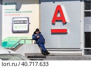 An elderly man stands between the branches of Sberbank and AlfaBank and chooses a Bank for himself (2019 год). Редакционное фото, фотограф Сергей Сергеев / Фотобанк Лори
