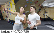 Girl gym coach and teen client talking in fitness room discussing possible options climbing. Стоковое видео, видеограф Яков Филимонов / Фотобанк Лори