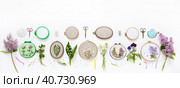 Needlework in summer holidays. Set of hand embroidery with satin ribbons of flowering plants in hoops and fresh flowers on white background. Panoramic view, banner. Flat lay, copy space. Стоковое фото, фотограф Виктория Катьянова / Фотобанк Лори