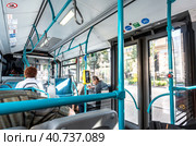 Интерьер современного московского городского автобуса с бесконтактным платежным терминалом и пассажирами внутри (2019 год). Редакционное фото, фотограф FotograFF / Фотобанк Лори