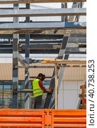 A man-welder fastens iron girders with a welding machine. Construction of the station. Стоковое фото, фотограф Юрий Поздников / Фотобанк Лори