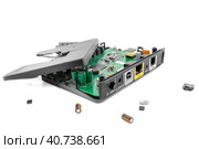 Разбитый на куски роутер или модем крупным планом на белом фоне. Fragmented Internet Modem Router on a white background close-up. Around lying parts of it. Стоковое фото, фотограф Валерий Елистратов / Фотобанк Лори