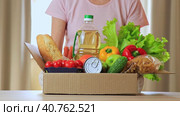 Безликая женщина ставит коробку с продуктами питания на стол. Набор различных продуктов. Концепция службы доставки на дом, покупок или коробки с пожертвованием. Фокус на передний план. Стоковое видео, видеограф Светлана Ельцова / Фотобанк Лори