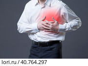 Heart attack, man with chest pain on gray background. Стоковое фото, фотограф Станислав Тарко / Фотобанк Лори