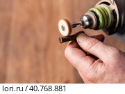 Restoration of an old Nagan revolver bullet case with a grinding machine. War finds of the early 20th century. Стоковое фото, фотограф Коханова Наталья / Фотобанк Лори