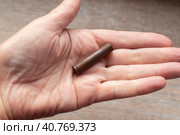 A cartridge case from an old Nagan revolver cartridge in the palm of your hand. War finds of the early 20th century. Стоковое фото, фотограф Коханова Наталья / Фотобанк Лори
