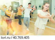 Smiling teenage girl practicing vigorous dance in studio. Стоковое фото, фотограф Яков Филимонов / Фотобанк Лори