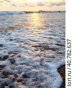 Sunset over sea. Beautiful sunset. Foamy waves roll over the sandy shore. Vityazevo, Anapa, Black Sea. Tourist mecca, health resort. Colorful clouds in the evening sky. The rays reflect off the water. Стоковое фото, фотограф Юлия Петровская / Фотобанк Лори