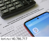 Упрощенная система налогообложения. Налоговая декларация, электронное приложение "Налоги" и калькулятор. Редакционное фото, фотограф Татьяна Т / Фотобанк Лори