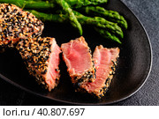 Tuna steak fried in sesame seeds served with asparagus. Стоковое фото, фотограф Татьяна  Бральнина / Фотобанк Лори