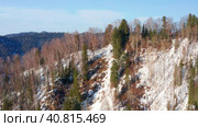 Горный Алтай зимой: лес на берегу Телецкого озера. Вид с воздуха. Altai mountains in winter: forest on the shores of Teletskoye Lake. Aerial view. Стоковое видео, видеограф Евгений Романов / Фотобанк Лори