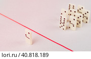 Expelled from the group, unable to cross the red line that separates them. Scene with group of domino. Concept of accusation guilty person, bulling or outcast in the team. Стоковое фото, фотограф Igor Tichonow / Фотобанк Лори