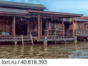 A serene warren of canals, floating houses and stilt houses over the Chao Phraya River, at Krung Thon Bridge (Saphan Sang Hi) (2019 год). Редакционное фото, фотограф Анна Кривицкая / Фотобанк Лори