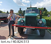 Москва. Городской фестиваль "Ретрорейс" на Воробьевых горах. Экскурсовод рядом с грузовиком ГАЗ-63 (2023 год). Редакционное фото, фотограф Илюхина Наталья / Фотобанк Лори