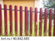 An iron fence enclosing a plot near a private house.Installation of fences. Стоковое фото, фотограф Александр Поташев / Фотобанк Лори