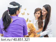 Mom and her infant daughter at the doctor's appointment. Healthy lifestyle concept. The doctor fills out the health questionnaire. Стоковое фото, фотограф Ирина Михайличенко / Фотобанк Лори