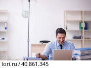 Young male employee suffering at workplace. Стоковое фото, фотограф Elnur / Фотобанк Лори