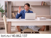 Young male employee working from home during pandemic. Стоковое фото, фотограф Elnur / Фотобанк Лори
