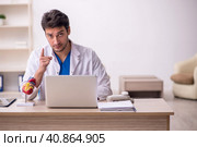 Young male doctor cardiologist sitting at the hospital. Стоковое фото, фотограф Elnur / Фотобанк Лори