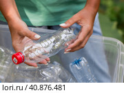 Container of plastic bottles. Garbage collection around the world. Clean the planet of plastic garbage. Ecology. A woman sorts garbage. Стоковое фото, фотограф Photojuli / Фотобанк Лори