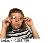 Cute 7 year old Caucasian girl looks into glasses. Eyes in a bunch. Ophthalmic problems in children. Myopia, exophoria and astigmatism. Selection of glasses. Isolate white background. Back to school. Стоковое фото, фотограф Юлия Петровская / Фотобанк Лори