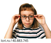 Cute 7 year old Caucasian girl looks into glasses. Eyes in a bunch. Ophthalmic problems in children. Myopia, exophoria and astigmatism. Selection of glasses. Isolate white background. Back to school. Стоковое фото, фотограф Юлия Петровская / Фотобанк Лори