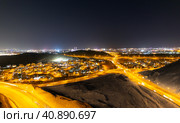 Aerial view of the night city of Muscat - the capital of the Sultanate of Oman. Road junctions and houses illuminated at night. Стоковое фото, фотограф Евгений Ткачёв / Фотобанк Лори