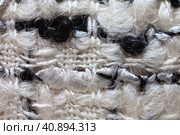 Close-up of black and white boucle suit with large knots. Textile background from interweaving of natural woolen and synthetic threads. Basis for tailoring fashionable comfortable office women's clothing. Стоковое фото, фотограф Виктория Катьянова / Фотобанк Лори