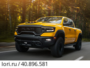 Novosibirsk, Russia - June  01, 2023:  yellow Dodge Ram Trx Havok Edition driving on road  on a warm summer day against the backdrop of  forest. Стоковое фото, фотограф Виталий Сова / Фотобанк Лори