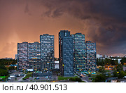 Многоэтажные современные жилые дома на закате перед дождем. Москва (2023 год). Редакционное фото, фотограф E. O. / Фотобанк Лори