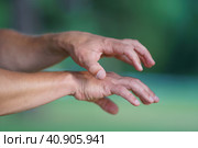 Photography of two tense female and male hands grabbing each other. They are catching or showing something . Natural green background. Close up image. Стоковое фото, фотограф YuryKara / Фотобанк Лори