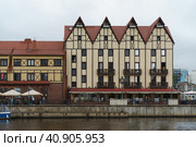Kaliningrad, Russia - June 20, 2022: Cityscape in rainy day. Bank of Pregol River and the Fishing village. Touristic location. Street cafe. tourists walking. Редакционное фото, фотограф YuryKara / Фотобанк Лори