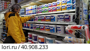 Buyer selects paint and plaster in the store (2018 год). Редакционное фото, фотограф Анна Кривицкая / Фотобанк Лори