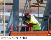 A man-welder fastens iron girders with a welding machine. Construction of the station. Стоковое фото, фотограф Юрий Поздников / Фотобанк Лори