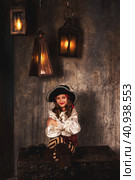 Portrait of smiling pirate sitting on chest arms crossed in hold of pirates ship, playful looking at camera. Charming child girl actress in corsair image. Theatre perform concept. Copy ad text space. Стоковое фото, фотограф Aleksandr Golubev / Фотобанк Лори