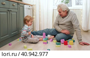 Old Grandfather and Little Boy Playing with Wooden Blocks on the Floor. Two Generation Family. Senior Man and Small Kid Having Fun Building Tower Laughing at Home. Happy Spending Time with Grandpa. 4K. Стоковое видео, видеограф Марина Демидюк / Фотобанк Лори
