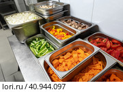 Stainless steel food trays on counter in professional kitchen. Стоковое фото, фотограф Сергей Толмачёв / Фотобанк Лори