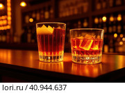 Two orange campari cocktails (Old-Fashioned Negroni Aperol Spritz) with ice on a contrast turquoise background, vertical. Light through the liquid. Top down view. Generative AI. Стоковое AI-изображение, AI-художник Sergey Grishin / Фотобанк Лори