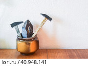 Two decorative hammers made of morion mineral (black quartz) and sample of morion mineral in the clay pot on wooden table. Стоковое фото, фотограф Татьяна Терехина / Фотобанк Лори