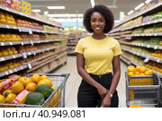 Attractive young black woman working in a supermarket, wearing a yellow shirt and dark trousers. Black Women owning small business posing looking at the camera with hand crossed. Business concept. Стоковая иллюстрация, иллюстратор Sergey Grishin / Фотобанк Лори