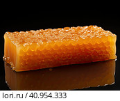 Golden wax honeycombs with honey lie on a shiny black background. Created by AI. Стоковое AI-изображение, AI-художник Ярославский Максим / Фотобанк Лори