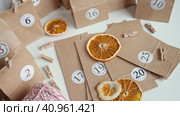 Christmas Advent Calendar. Paper bags, dry fruits, string on white table. Seasonal activity for kids, family winter holidays. Handmade tinkered calendar, natural material. DIY. Soft Focus. Top View. Стоковое видео, видеограф Марина Демидюк / Фотобанк Лори