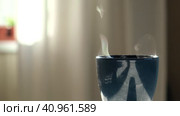 Steaming Cup of Coffee or Tea on Table. White linen Tablecloth. Close-up ceramic blue mug with smoke on old table in dining room interior background. Hot Drink Concept. Cozy Morning. Стоковое видео, видеограф Марина Демидюк / Фотобанк Лори