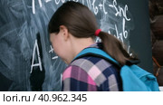 Sad pupil trying to solve an example. Schoolgirl stands with her forehead on the blackboard. Teenage girl solving advanced mathematical problems and banging his head on chalkboard. This is too hard. Стоковое видео, видеограф Марина Демидюк / Фотобанк Лори