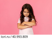 Negative human emotions, reactions and feelings. Isolated shot of moody displeased angry little girl crossing arms on her chest, pouting lips, having offended facial expression, being capricious. Стоковое фото, фотограф Ирина Михайличенко / Фотобанк Лори