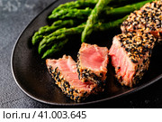 Tuna steak fried in sesame seeds served with asparagus. Стоковое фото, фотограф Татьяна  Бральнина / Фотобанк Лори