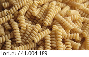 Gluten Free Cornmeal Pasta Wallpaper. Spiral Raw Macaroni from Corn and Rice flour rotating on Turntable. Close Up Top View. Uncooked Pasta Spinning. Full Frame. Food Background. Fusilli Bucati Corti. Стоковое видео, видеограф Марина Демидюк / Фотобанк Лори